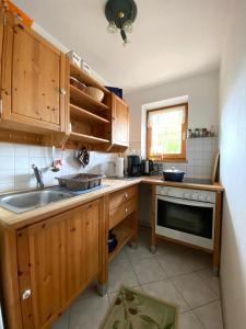 a kitchen with wooden cabinets and a sink at Villa Angélique in Bad Kohlgrub