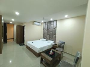 a bedroom with a bed and a table and a chair at The Cape Grace Hotel in Jalandhar