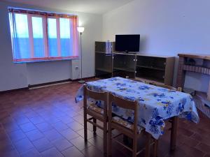 a dining room with a table and chairs and a television at La Casa di Giorgio in Marina di Camerota