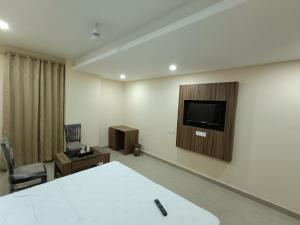 Pokój z łóżkiem i telewizorem na ścianie w obiekcie The Cape Grace Hotel w mieście Dźalandhar