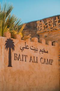 a sign for bat all camp with a palm tree at Bait Ali in Wadi Rum