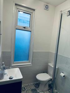 a bathroom with a toilet and a sink and a window at Stylish Town House - Modern double room - 3 in Parkside