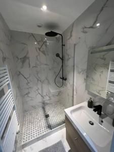 La salle de bains blanche est pourvue d'une douche et d'un lavabo. dans l'établissement MIRA - Sublime apartment close to train station, à Corbeil-Essonnes