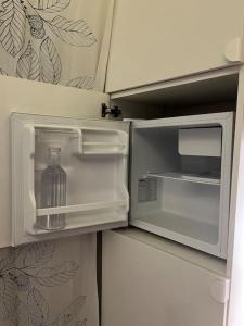 - un réfrigérateur ouvert avec une bouteille à l'intérieur dans l'établissement Casa de invitados, a pie de playa, en La Torre Verde, à El Puerto de Santa María