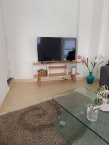 uma sala de estar com uma televisão e uma mesa de vidro em SAN BARTOLO BEACH BUILDING em San Bartolo