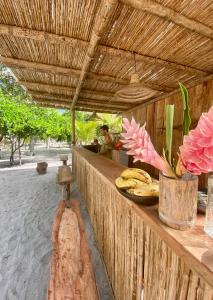 un comptoir en bois avec des bananes et des fleurs. dans l'établissement Manoush Beach, à Buritaca