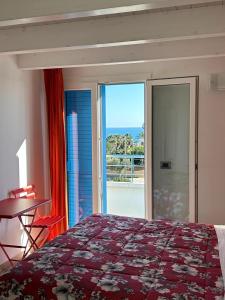 a bedroom with a bed and a view of the ocean at Villa Patrizia Selinunte in Marinella di Selinunte