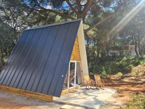 une petite maison avec un toit bleu et des chaises dans l'établissement FALCOARIA de Santa Efigenia, à Setúbal