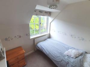 a small bedroom with a bed and a window at Countryside 3 Bed Detached Cottage in Royal Wootton Bassett