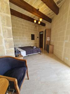 a room with a bed in a brick wall at Splendid House Victoria Gozo in Victoria