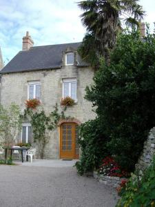 a brick house with a wooden door and a table at Gîtes de l'Eglise WACO in Sainte-Mère-Église