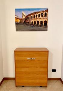 - une commode en bois dans une pièce ornée d'une peinture murale dans l'établissement Top Apartment 2, à Castel d'Azzano