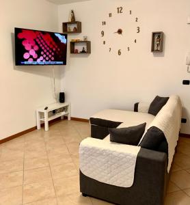 a living room with a couch and a clock on the wall at Top Apartment 2 in Castel d'Azzano