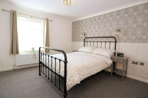 ein Schlafzimmer mit einem schwarzen Bett und einem Fenster in der Unterkunft Cute Central Georgian Cottage in Hastings