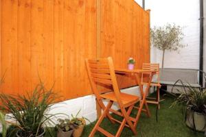 einen Holztisch und Stühle auf einer Terrasse mit Pflanzen in der Unterkunft Cute Central Georgian Cottage in Hastings