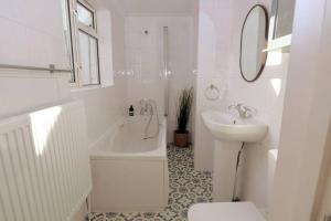 a bathroom with a sink and a toilet and a bath tub at Cute Central Georgian Cottage in Hastings