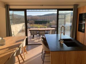 a kitchen with a view of a patio with a table at Vue Ventourist - vakantieloft in Malaucène