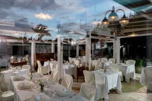 uma sala de jantar com mesas brancas e cadeiras brancas em UNICA Assisi agri-charming house em Assis