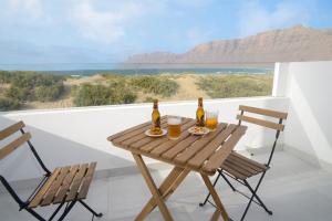 a table with two chairs and two bottles of beer at Luxury Buenavista Famara in Famara