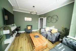 a living room with a couch and a table at Highgate Beach House in Cleethorpes