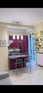 a kitchen with purple cabinets and a table and chairs at Terrazza Porta Venezia HOWME in Milan