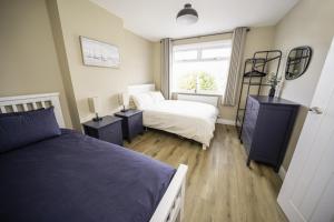 a bedroom with two beds and a window at Highgate Beach House in Cleethorpes