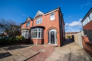 a red brick house with a white door at Highgate Beach House in Cleethorpes