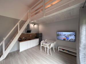 a living room with a staircase and a table and a tv at Apartament Pod Jaworami z antresolą in Jelenia Góra