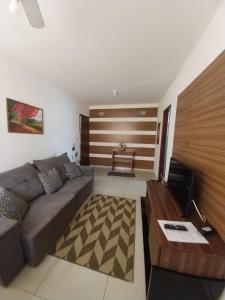 een woonkamer met een bank en een tafel bij Apto Richard Shopping in Campos dos Goytacazes