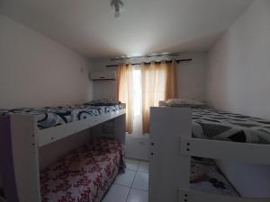 twee stapelbedden in een kamer met een raam bij Apto Richard Shopping in Campos dos Goytacazes