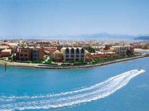 a boat in the water in front of a city at Marena Hurghada in Hurghada