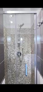 y baño con ducha y puerta de cristal. en Terrazza Porta Venezia HOWME en Milán