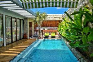 a swimming pool in the middle of a house at TS SUITES Seminyak Bali in Legian