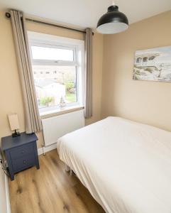 a bedroom with a white bed and a window at Highgate Beach House - Great for family stays and contractors in Cleethorpes