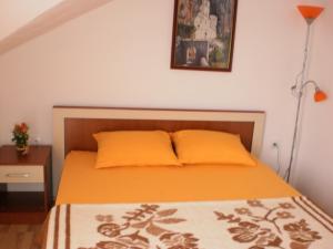 a bedroom with a bed with an orange bedspread at Apartments Odzic in Tivat