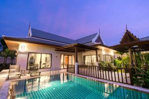 uma villa com piscina em frente a uma casa em Pimann Buri Pool Villas Ao Nang Krabi Sha Plus em Praia de Ao Nang