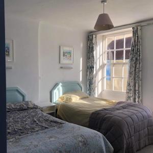 - une chambre avec 2 lits et une fenêtre dans l'établissement Admiralty House, à Weymouth