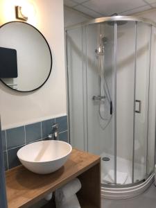 een badkamer met een wastafel en een douche bij Hôtel de la Glane in Oradour-sur-Glane