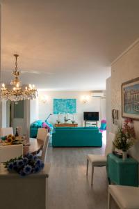 een woonkamer met een blauwe bank en een tafel bij Blue Lake Home in Desenzano del Garda