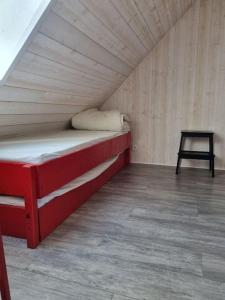 Cama roja en una habitación pequeña con mesa en Studio au pied des pistes en Allos