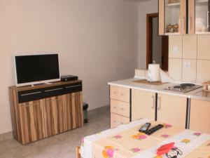 a room with a tv on a counter with a table at Apartments Odzic in Tivat