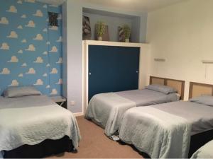 1 dormitorio con 2 camas con nubes pintadas en la pared en Admiralty House, en Weymouth