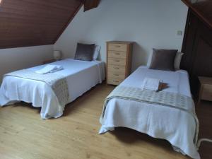 two beds sitting next to each other in a bedroom at casa cardeal saraiva in Ponte de Lima