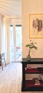 ein Wohnzimmer mit einem Tisch und einer Topfpflanze in der Unterkunft Central City Rooms m09 Apartment in Bologna