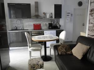 ein Wohnzimmer mit einem Tisch und Stühlen in einer Küche in der Unterkunft L'Amiral in Vichy