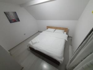 a bedroom with a white bed with white sheets and pillows at Casa Sandu in Topliţa +22 photos