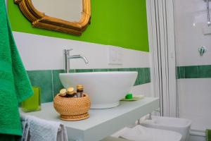 baño con lavabo y pared verde en Casa Francesca zona Gemelli en Roma