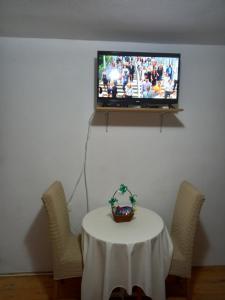 a room with a table and a tv on a wall at Sobe Dujakovic 