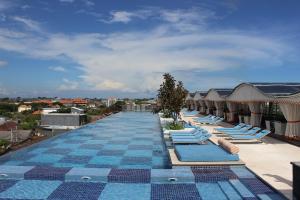 a row of lounge chairs on the roof of a building at TS SUITES Seminyak Bali in Legian