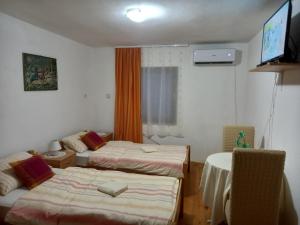 um quarto com duas camas e uma televisão em Sobe Dujakovic 